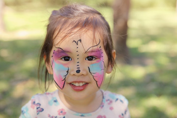 Cute girl getting face paintied as a butterfly