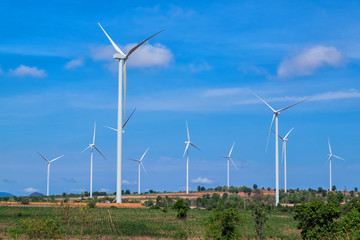 Wind turbines with blue sky and green field 