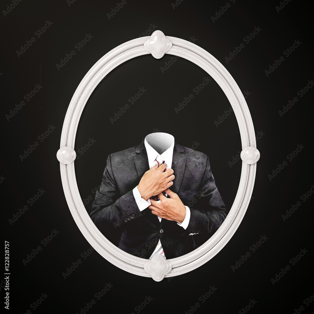 Invisible man in black suit, in white oval picture frame on black wall ...