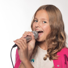 Emotional Blonde Girl In A Pink Jacket With A Microphone
