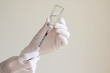 Nurse is  drawing  solution into syringe from vial for preparing