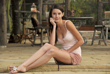 Beautiful Young Model Sitting On Patio Of Ranch Home
