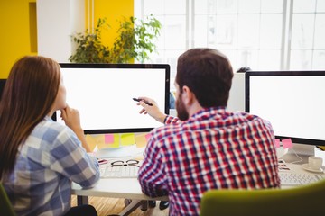 Poster - Businessman showing something to female coworker on computer