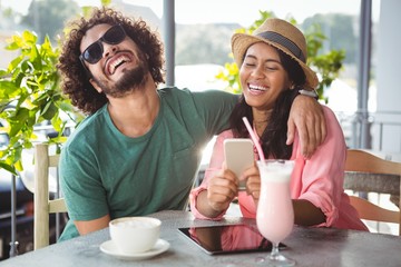 Poster - Couple having fun while using mobile phone