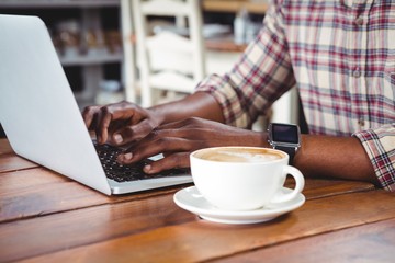 Poster - Mid-section of a man using laptop