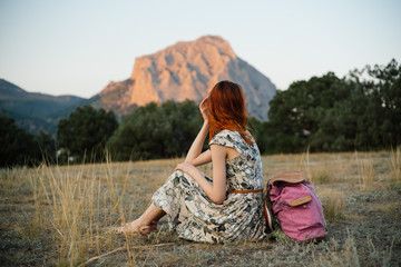 A young woman traveling in the summer in the mountains
