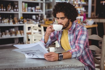 Poster - Man reading newspaper while having coffee