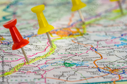 Fototapeta na szkło Colourful Pushpins on a Map Highlighting the Stops of a Planned Road Trip