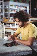 Poster - Man using mobile phone while having coffee