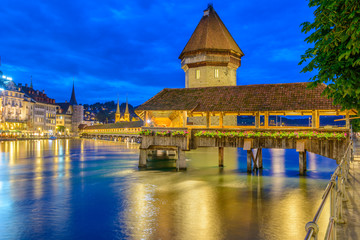 Night view towards Chapel Bridge (Kapellbruecke) together with the octagonal tall tower (Wasserturm) it is one of the Lucerne's most famous tourists attraction