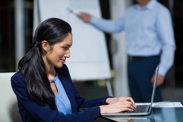 Wall Mural - Portrait of businesswoman working on laptop