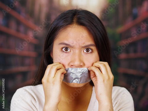 Young Brunette Woman Wearing White Sweater Gagged With Duct Tape Covering Mouth Facing Camera Young Brunette Woman Wearing White Sweater Gagged With Duct Tape Covering Mouth Facing Camera