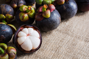 Mangosteen and cross section showing the thick purple skin and w