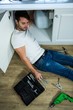 © WavebreakMediaMicro - Man repairing a kitchen sink