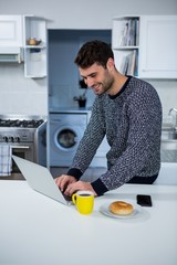 Poster - Man using laptop in the kitchen