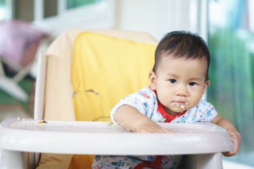 Wall Mural - Asian baby eating food by himself