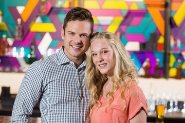 Wall Mural - Cute couple standing together in bar