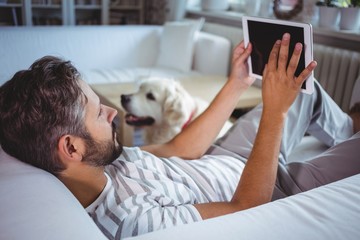 Poster - Man using digital tablet in living room
