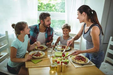 Woman serving meal to her family