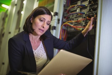 Aufkleber - Technician using laptop while analyzing server