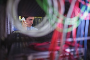 Aufkleber - Technician talking on mobile phone while checking cables