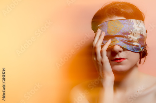 Fotografie, Obraz Portrait of a woman with covered eyes in rays of light. Techniqu