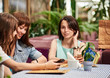 © Denys Kurbatov - girlfriends at cafe ordering from menu