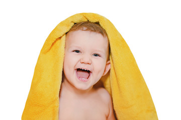 Happy little baby under a yellow towel isolated in white backgro