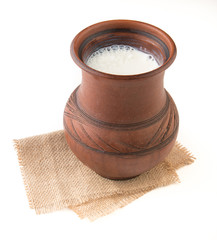 Wall Mural - Rustic milk in a clay mug and clover flowers isolated on white background