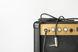 Black guitar amplifier with jack cable on white background