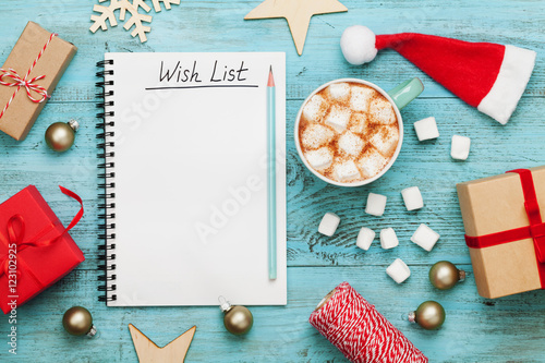 Photographie Cup of hot cocoa or chocolate with marshmallow, holiday decorations and notebook with wish list on turquoise vintage table from above, christmas planning concept