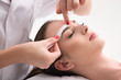 Experienced cosmetician pulling out brows
