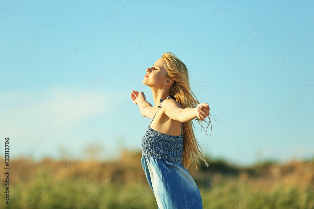 Happy young woman on blue sky background