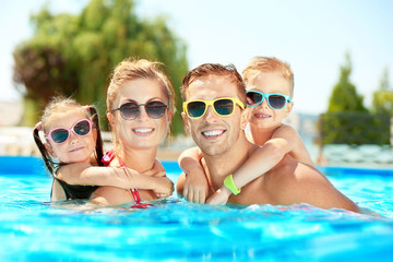 Wall Mural - Happy family in swimming pool at water park