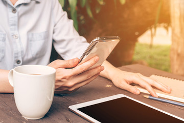 Close up hand asia woman using phone in coffee shop with vintage