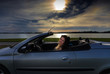 young woman in cabriolet car at lake night