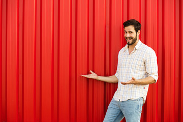 Wall Mural - adult man in red wall pointing one side of his