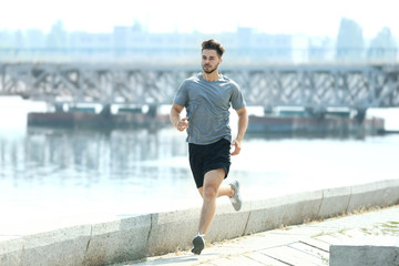 Wall Mural - Young man jogging outdoors