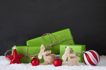 red and green christmas decoration, snow, black cement wall