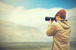 © twinsterphoto - travel photographer journalist holding a dslr camera in mountain background (Vintage tone)
