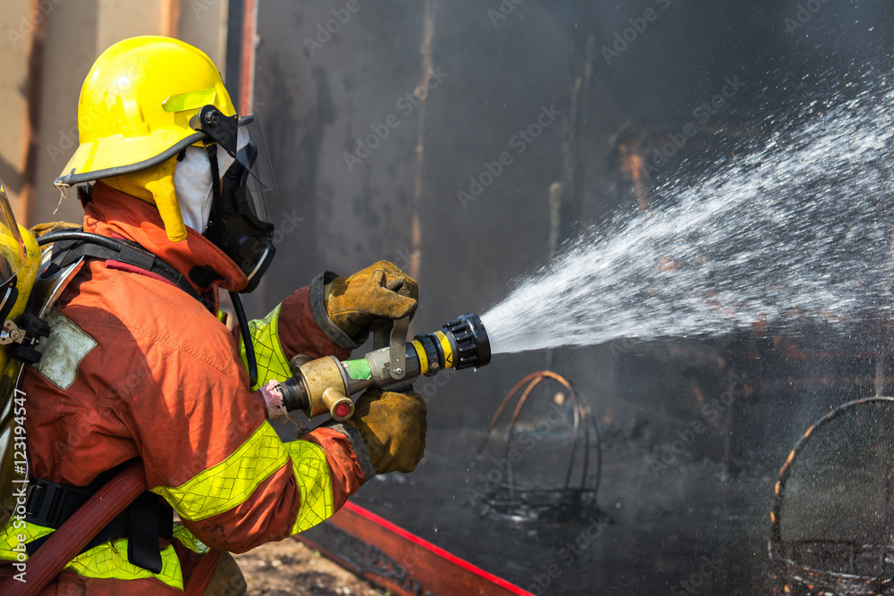 firefighter hold and adjust nozzle and fire hose spraying water Stock ...