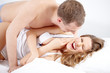 © pressmaster - A young woman lying in bed and laughing at her lover