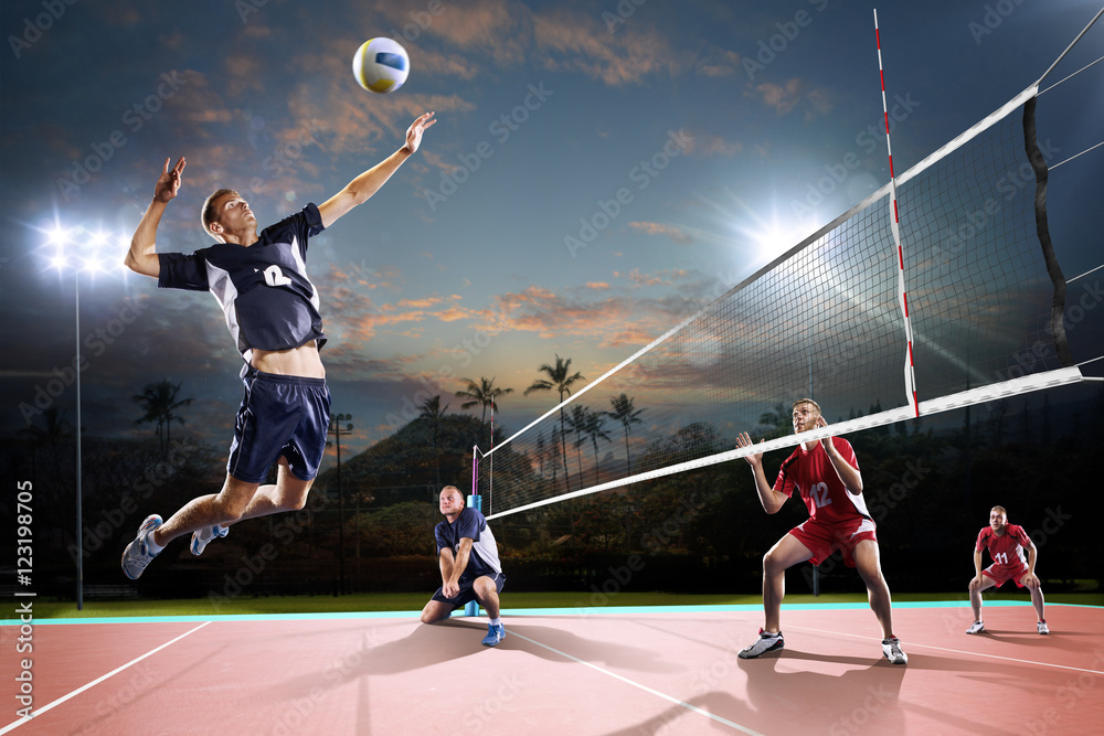 Professional volleyball players in action on the night court - obrazy, fototapety, plakaty 