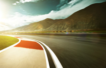Wall Mural - Motion blurred racetrack with mountain background , warm mood