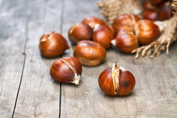 Roasted sweet chestnuts on grey rustic wooden table. Copy space