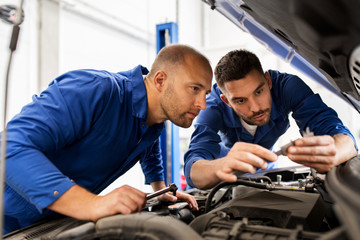 Poster - mechanic men with wrench repairing car at workshop