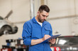 © Syda Productions - auto mechanic man with clipboard at car workshop