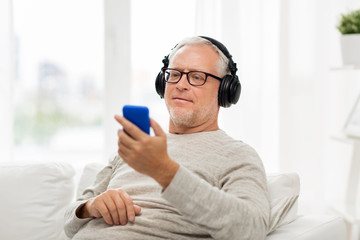 Canvas Print - happy senior man with smartphone and headphones