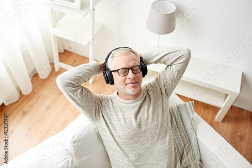 Fotografia happy man in headphones listening to music at home