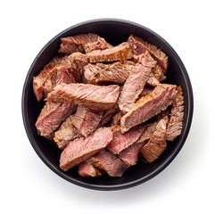 Wall Mural - Bowl of grilled beef slices isolated on white, from above